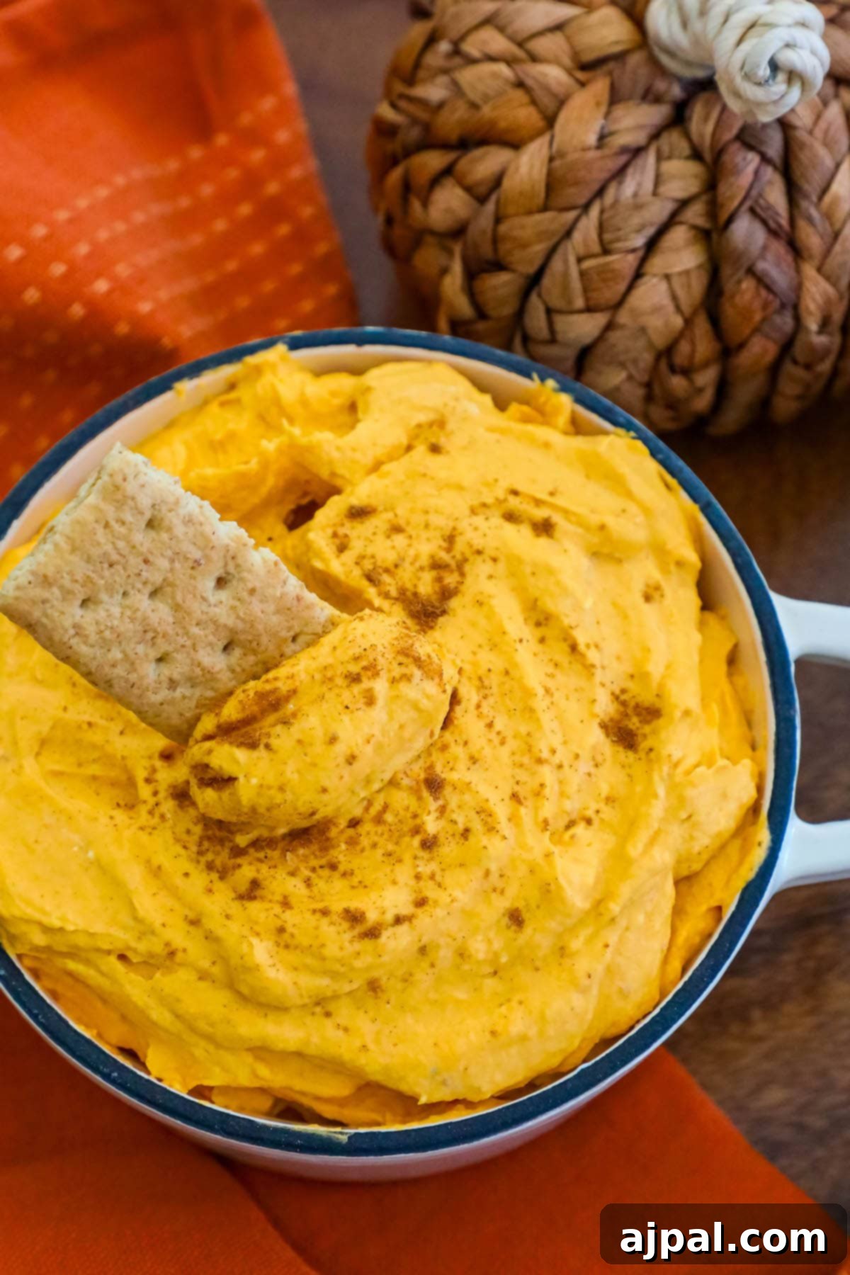 Creamy Pumpkin Dream 3 cool whip pumpkin pie fluff in a white bowl with graham crackers in it