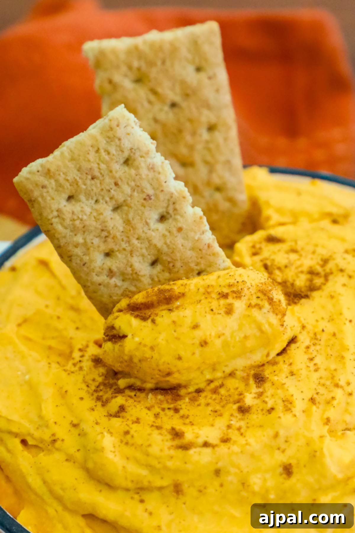 Creamy Pumpkin Dream 6 cool whip pumpkin pie fluff in a white bowl with graham crackers in it