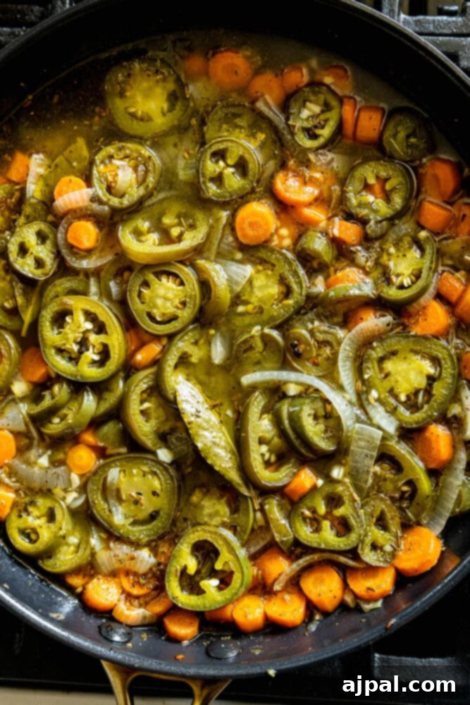 Zesty Carrot Jalapeno Relish 8 a pan with browned sliced carrots, jalapenos, onions, stock, bay leaves, and herbs in it