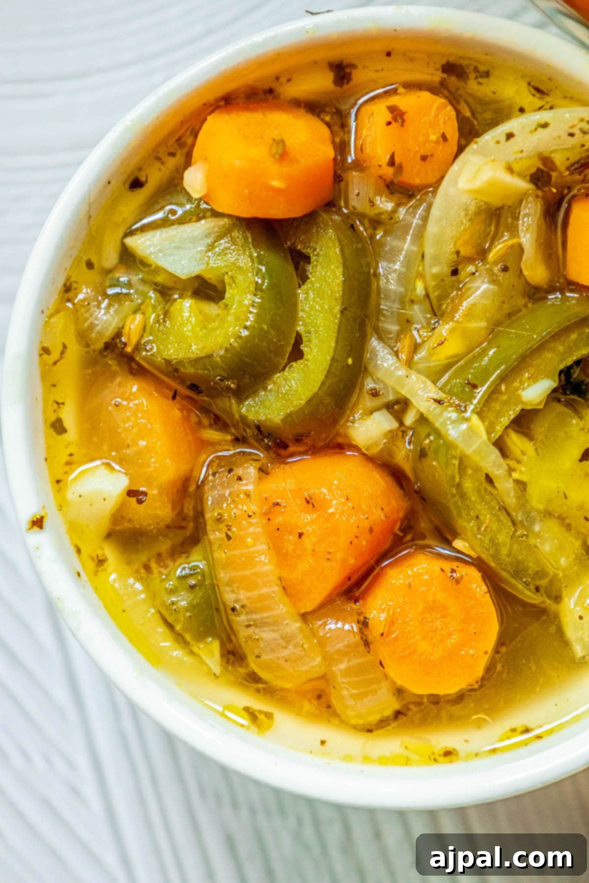 Zesty Carrot Jalapeno Relish 10 a white bowl with sliced pickled carrots and jalapenos