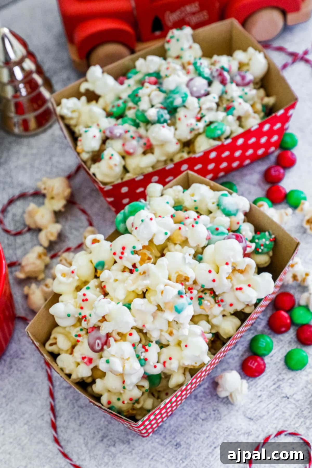 Delicious chocolate sprinkle popcorn with candies, elegantly presented in a striped box.
