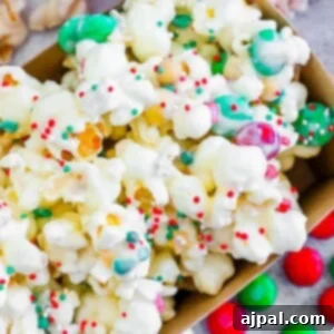 chocolate sprinkle popcorn with candies in a striped box.