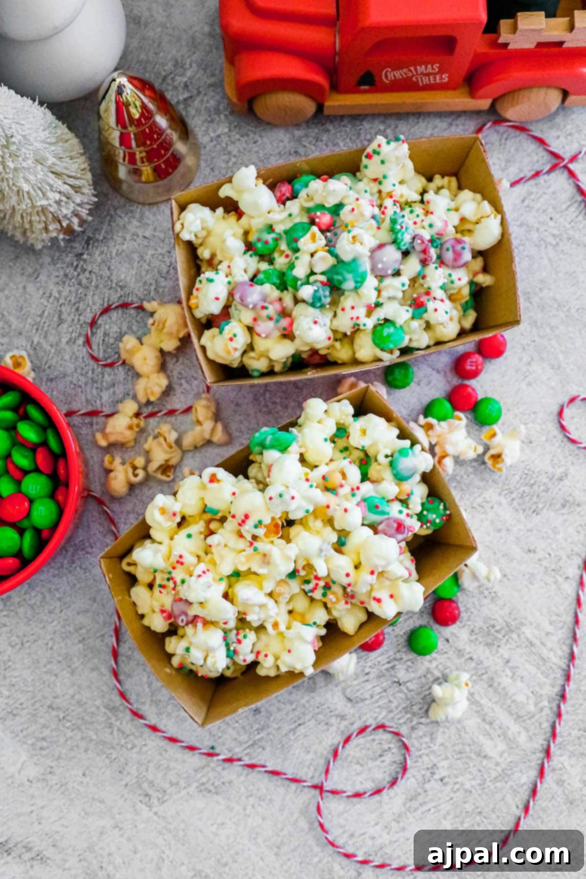 Two cheerful boxes of popcorn adorned with chocolate and sprinkles, perfect for holiday gatherings.