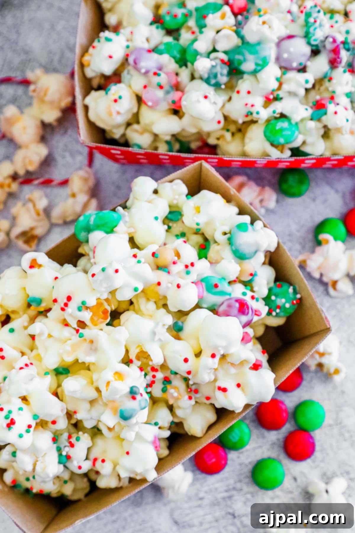 A close-up view of reindeer popcorn, beautifully coated in white chocolate, vibrant sprinkles, and festive candies.