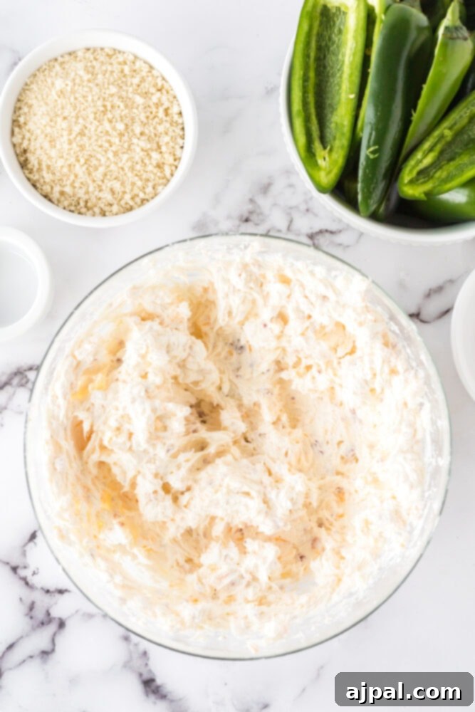 The creamy filling mixture of cream cheese, shredded Monterey Jack, crumbled bacon, onion powder, and garlic salt, perfectly combined in a glass bowl.