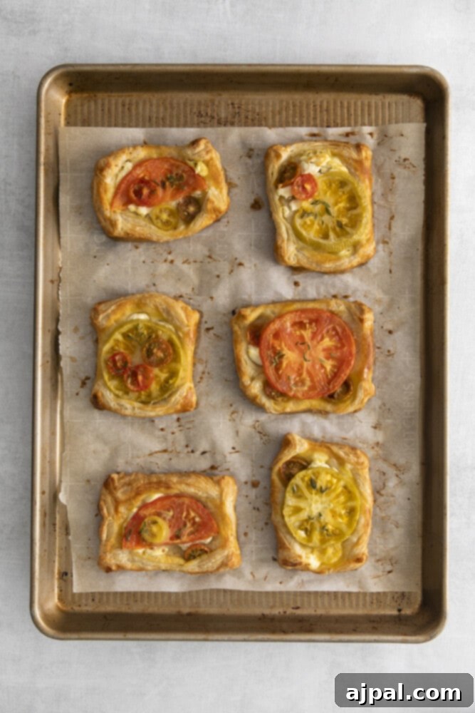 Tomato Goat Cheese Tarts 9 Six beautifully assembled goat cheese and tomato tarts, brushed with egg wash and ready for the oven, promising a golden finish.