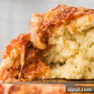 slice of deep dish pizza with pepperoni on a spatula with stringy melted cheese
