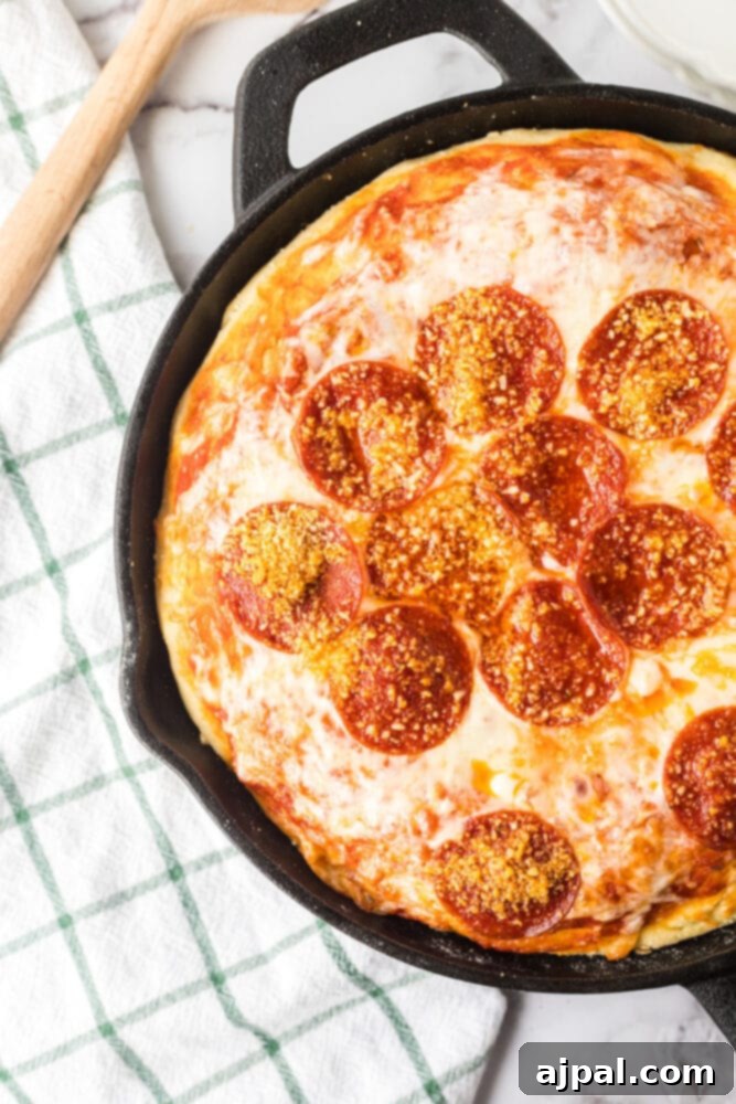 A freshly baked deep dish pizza, still in its cast iron skillet, presented on a table with a golden-brown crust and bubbling cheese.
