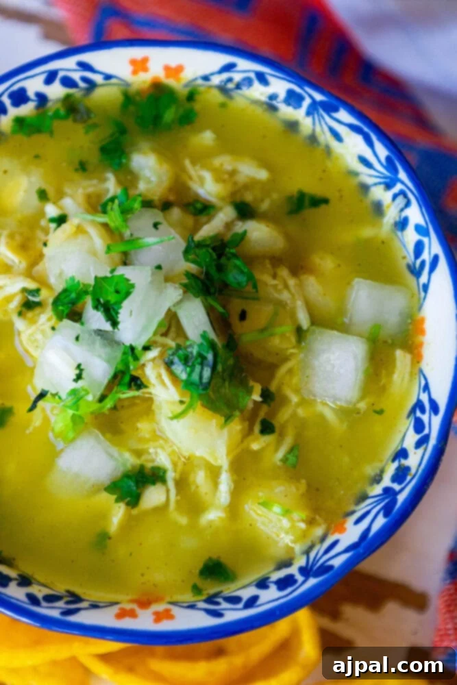 Easy green chicken posole in a blue bowl.