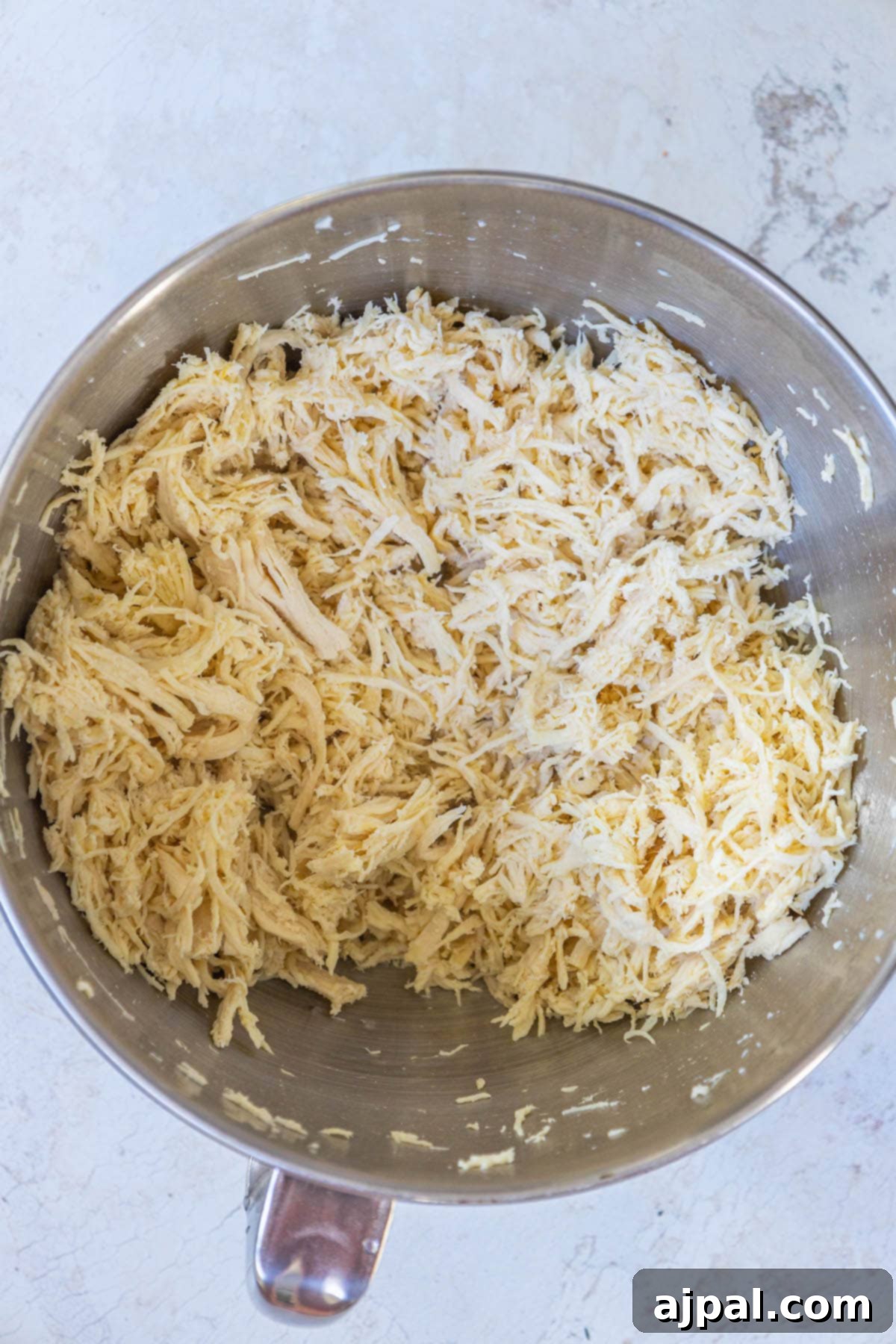 shredded chicken in a stand mixer bowl