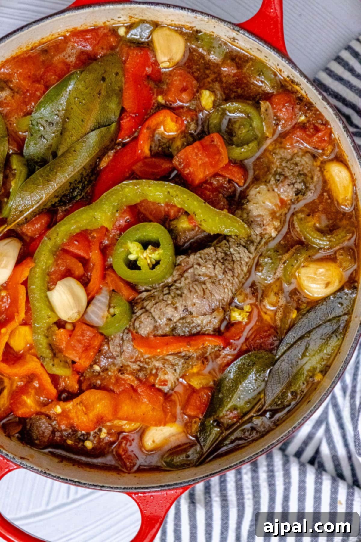 Spicy Mexican Pot Roast 4 A Dutch oven containing a fish stew, richly colored with fajita vegetables, hinting at a flavorful and vibrant meal.