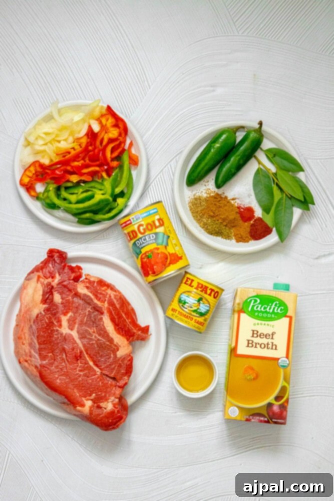 Spicy Mexican Pot Roast 5 Various raw ingredients for Mexican pot roast, including a cut of beef, beef stock, fresh bell peppers, onions, and jars of herbs and spices, laid out on a table.