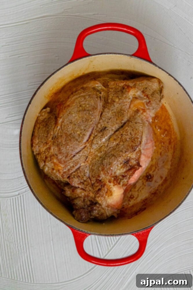 Spicy Mexican Pot Roast 7 A perfectly browned pot roast, seared on all sides, resting in the bottom of a Dutch oven, ready for the next cooking stage.