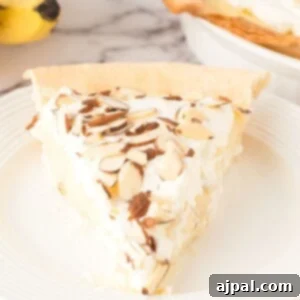 Creamy Banana Delight 16 slice of banana cream pie with whipped topping and sliced almonds on top on a white plate