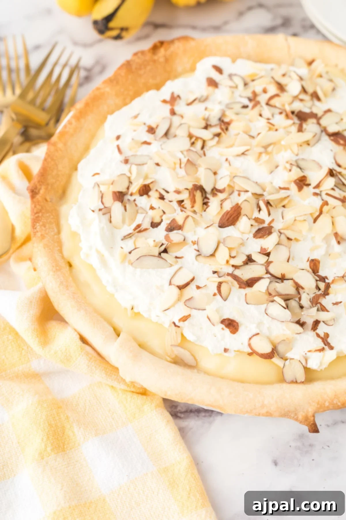 Creamy Banana Delight 4 custard banana pie with whipped topping and sliced almonds in a pie pan