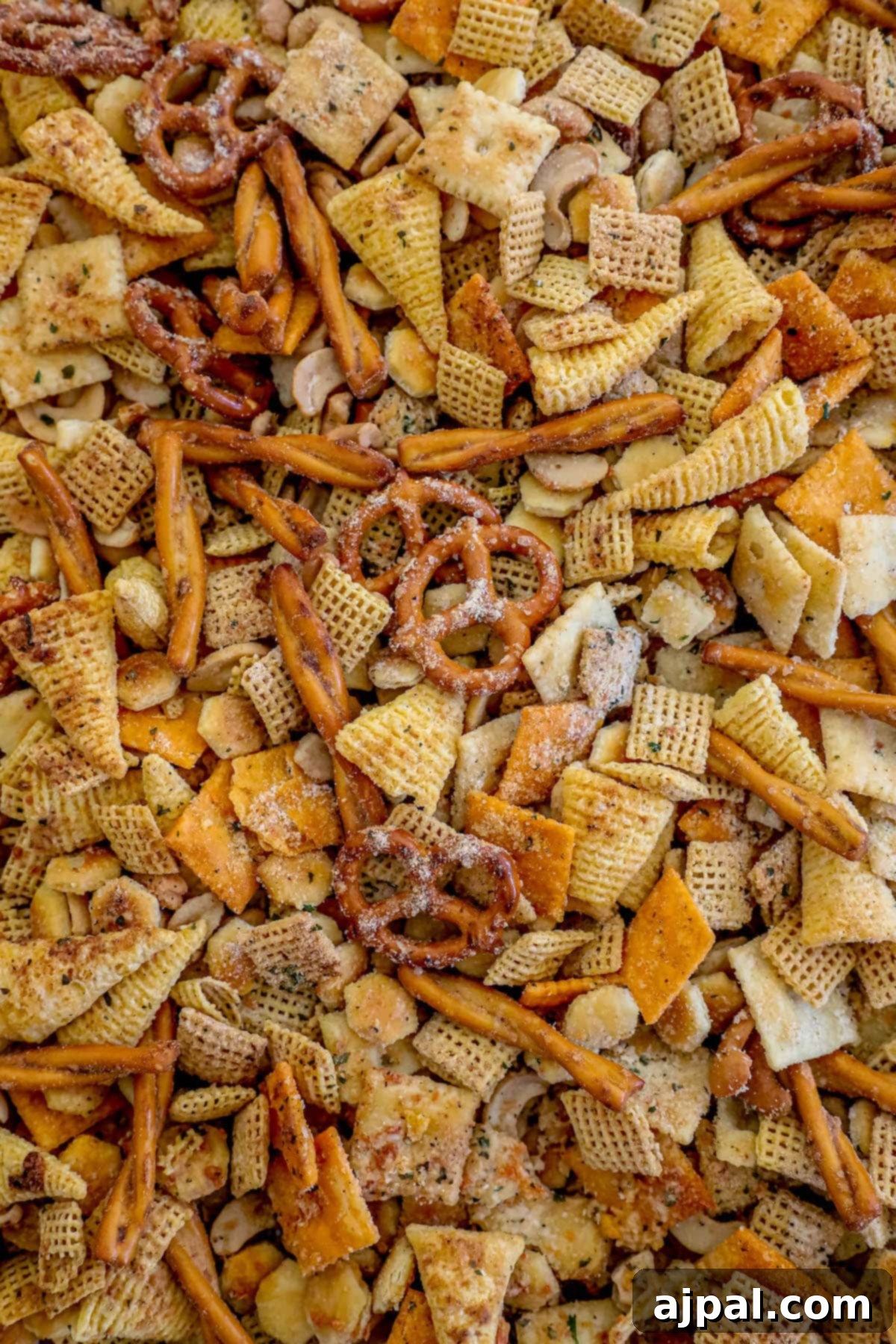 A close-up of Ranch Chex Mix spread evenly on a baking sheet, featuring pretzels, Bugles, cheese crackers, and oyster crackers coated in rich ranch seasoning.