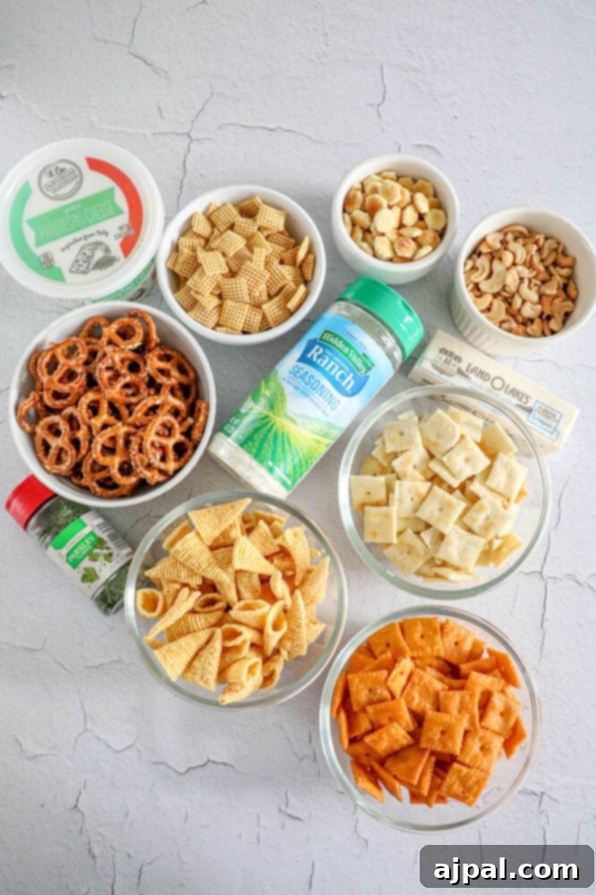 An array of ingredients for Ranch Chex Mix laid out on a table, including ranch seasoning, Chex cereal, pretzels, cheese crackers, nuts, and fresh herbs.
