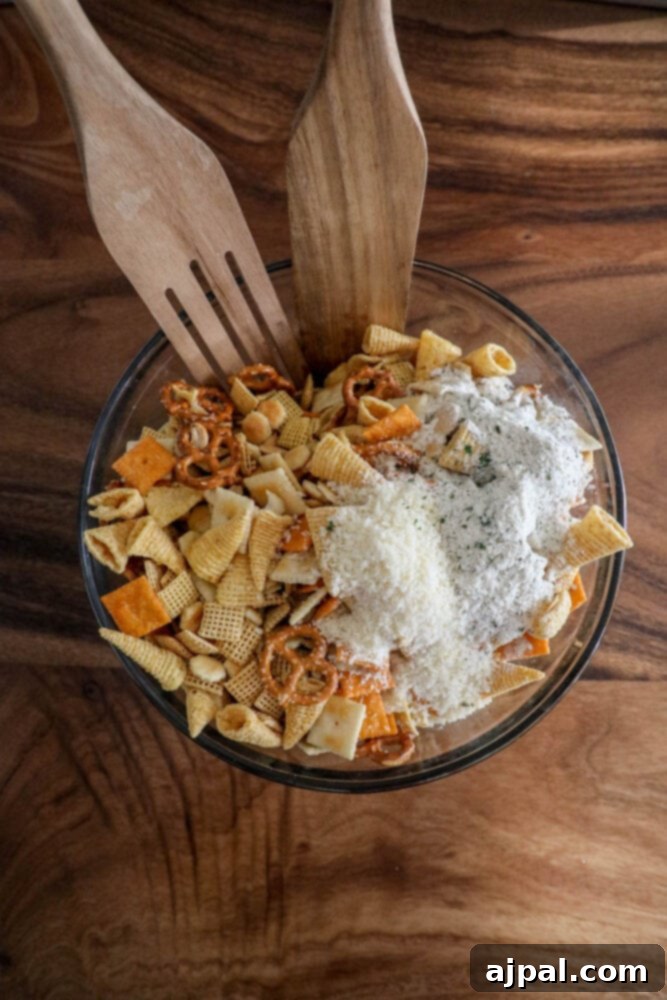 Ranch seasoning powder being generously sprinkled over a bowl of corn cereal, corn chips, pretzels, and crackers, ensuring full coverage.