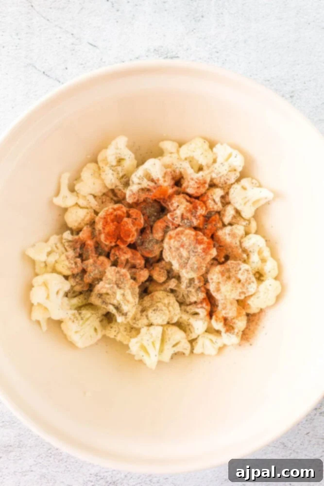 seasoning on raw cauliflower in a bowl