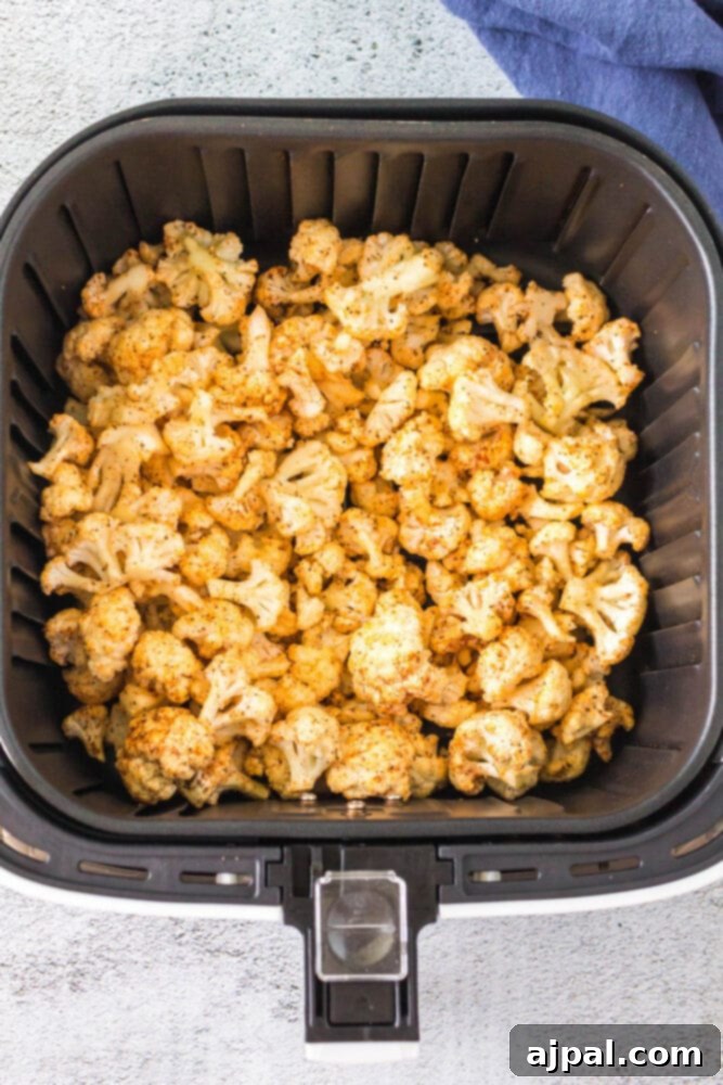 seasoned cauliflower in an air fryer basket
