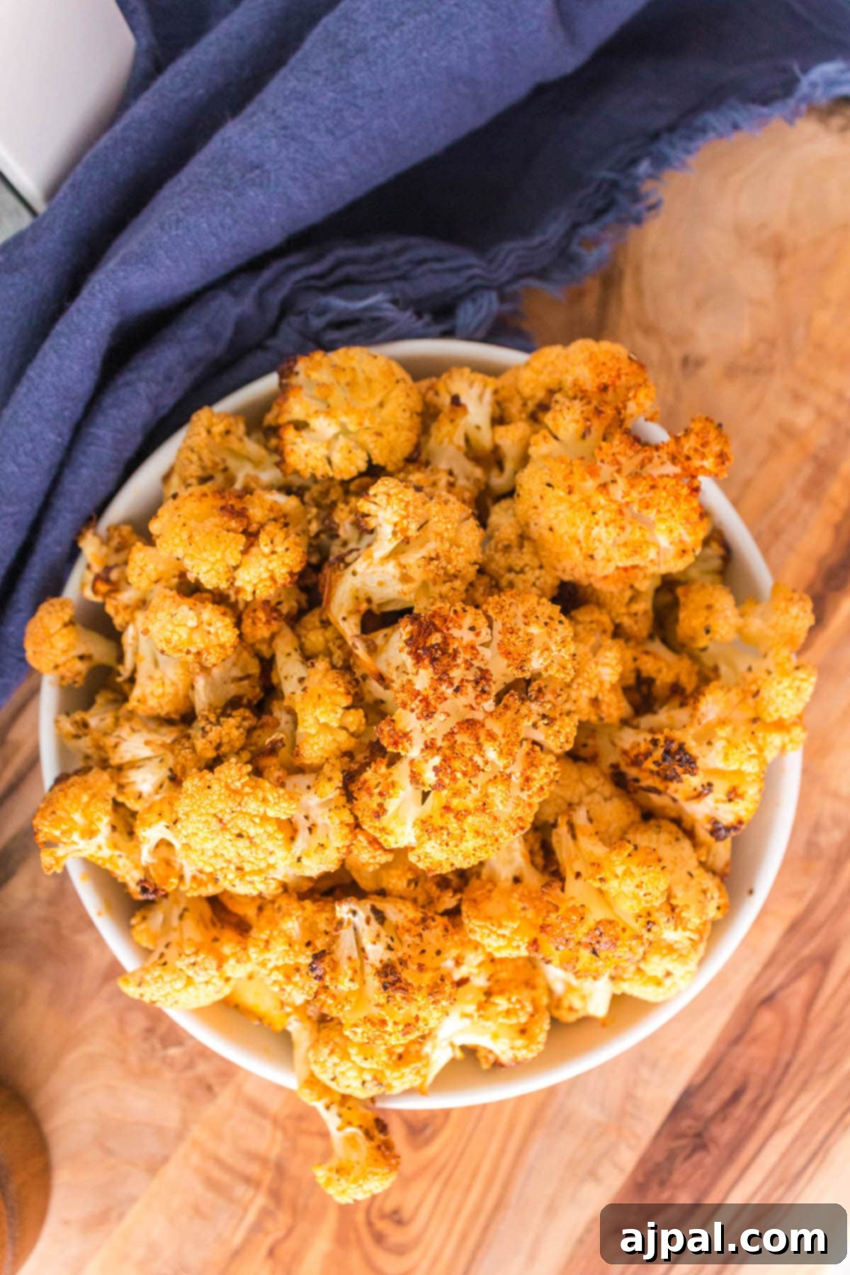 browned seasoned cauliflower in a white bowl on a table