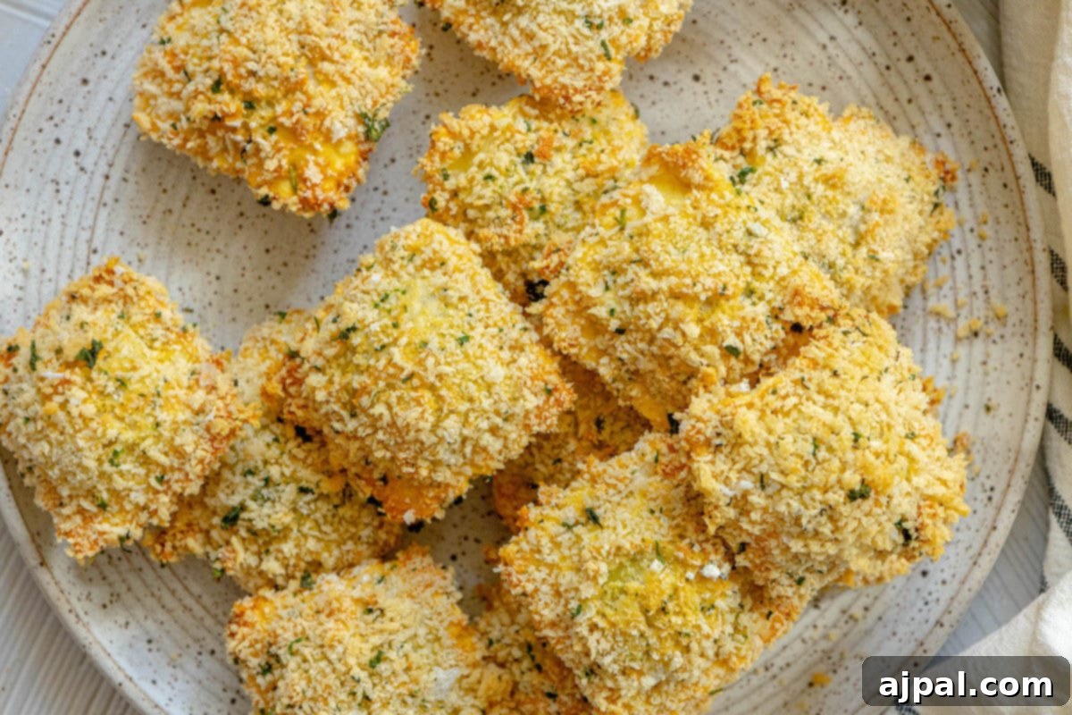 Crunchy baked breaded ravioli on a white speckled plate