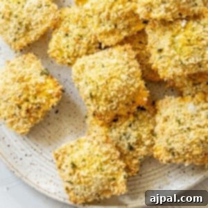 Crunchy baked breaded ravioli on a white speckled plate