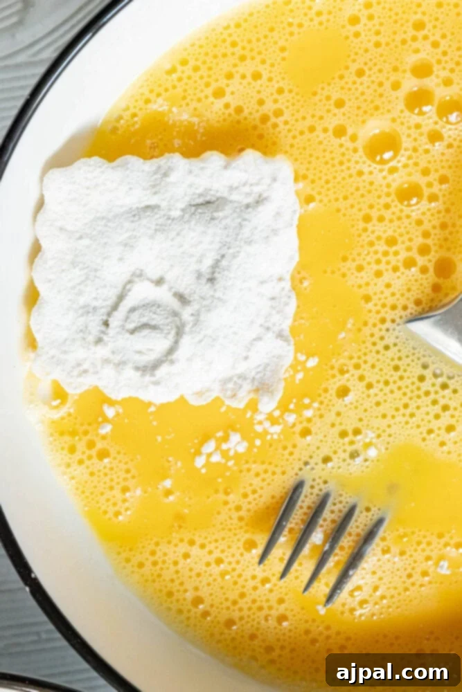 Flour-dredged ravioli being dipped into a bowl of whisked egg mixture