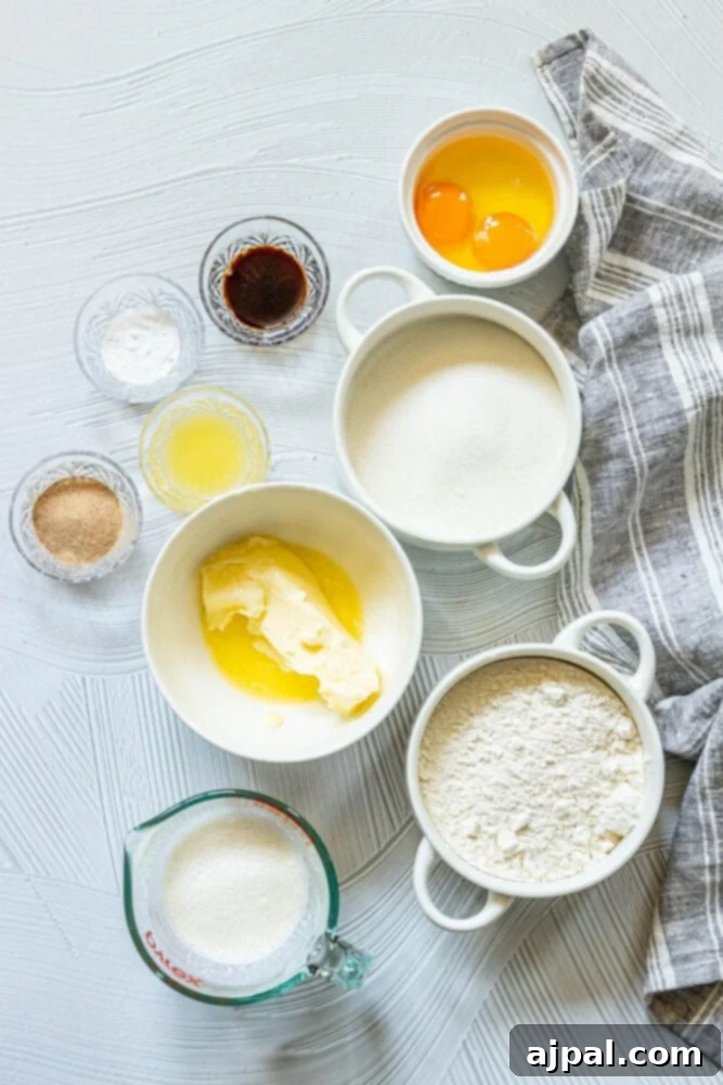 Bowls of essential donut hole ingredients: flour, sugar, eggs, butter, milk, and vanilla extract, ready for mixing.