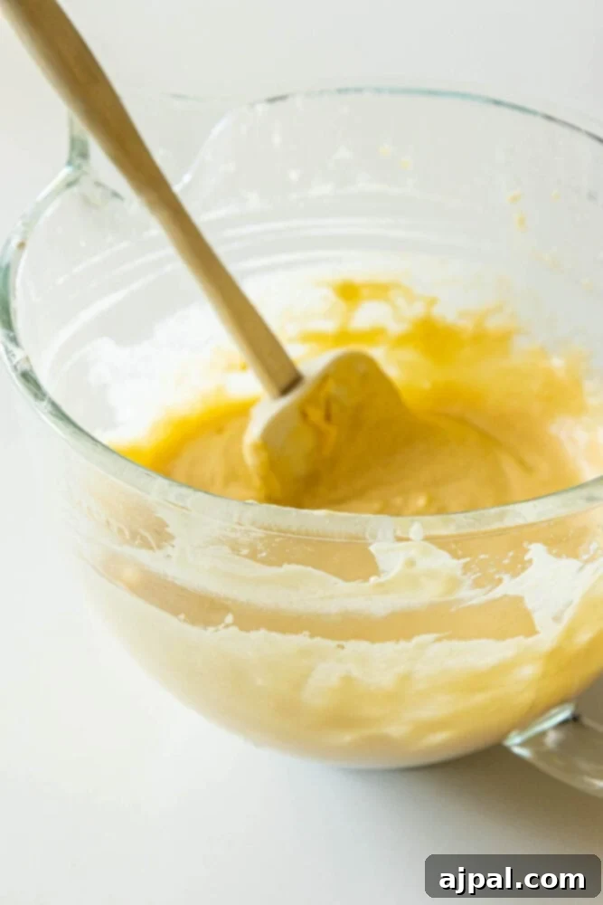 A bowl of perfectly mixed donut hole batter, showcasing its smooth and slightly thick consistency.