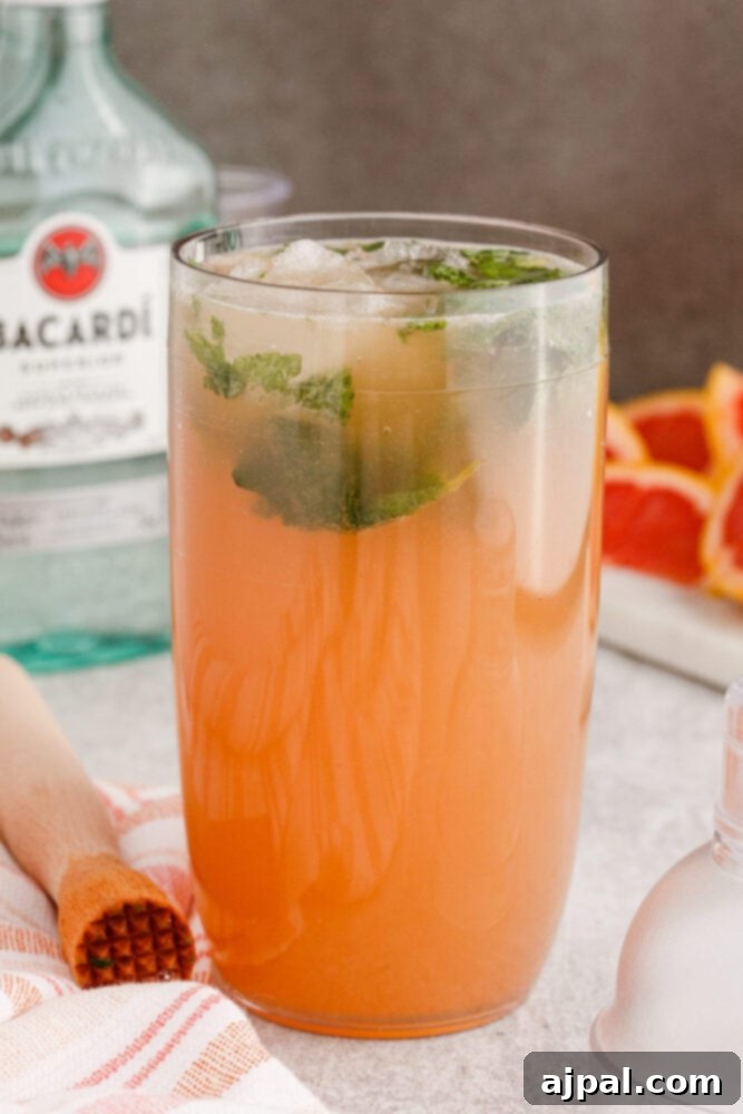 a cocktail shaker full of grapefruit mojito cocktail