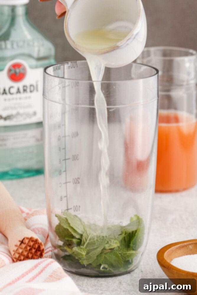 pouring lime juice in a cocktail shaker with mint