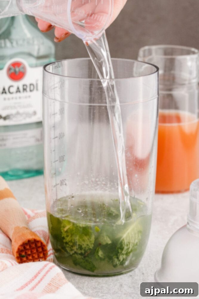 pouring rum into a cocktail shaker with sugar and mint