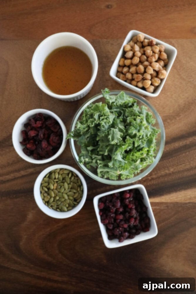 Jeweled Chickpea Pomegranate Salad 5 chickpeas, kale, dried cranberries, pomegranate arils, pepitas, dressing, sunflower seeds on a table