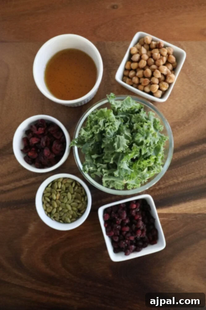 Mediterranean Chickpea Pomegranate Salad 5 chickpeas, kale, dried cranberries, pomegranate arils, pepitas, dressing, sunflower seeds on a table