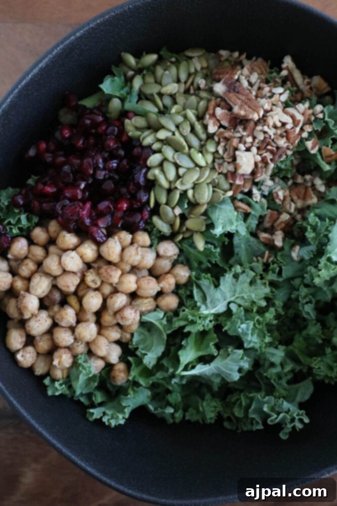 Jeweled Chickpea Pomegranate Salad 6 chickpeas, kale, dried cranberries, pomegranate arils, pepitas, dressing, sunflower seeds in a large bowl