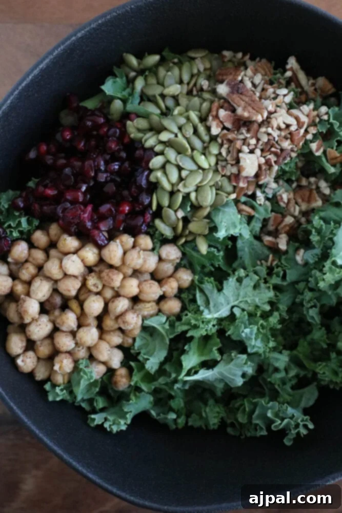 Mediterranean Chickpea Pomegranate Salad 6 chickpeas, kale, dried cranberries, pomegranate arils, pepitas, dressing, sunflower seeds in a large bowl