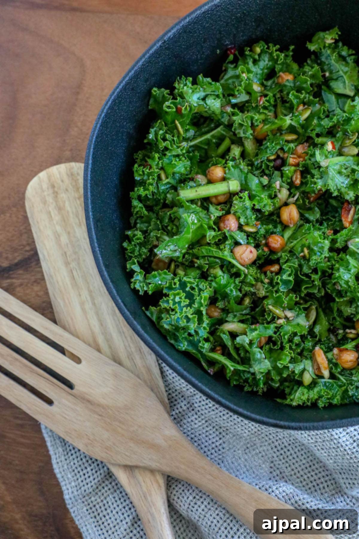 Jeweled Chickpea Pomegranate Salad 8 kale salad in a bowl with chickpeas, dried cranberries, pomegranate arils, pepitas, and dressing
