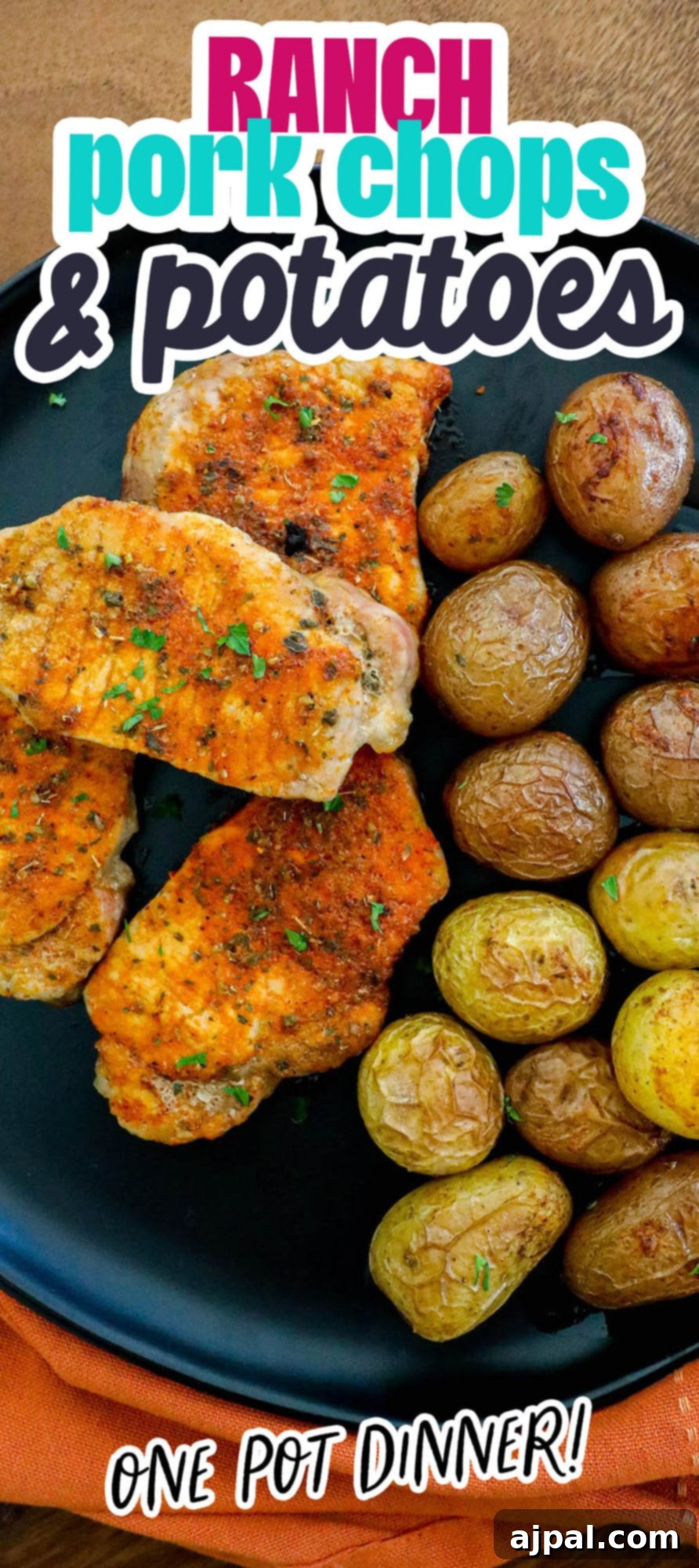 Zesty Ranch Pork Chops and Roasted Potatoes 13 browned seasoned pork chops with potatoes on a black plate next to a bottle of ranch dressing seasoning