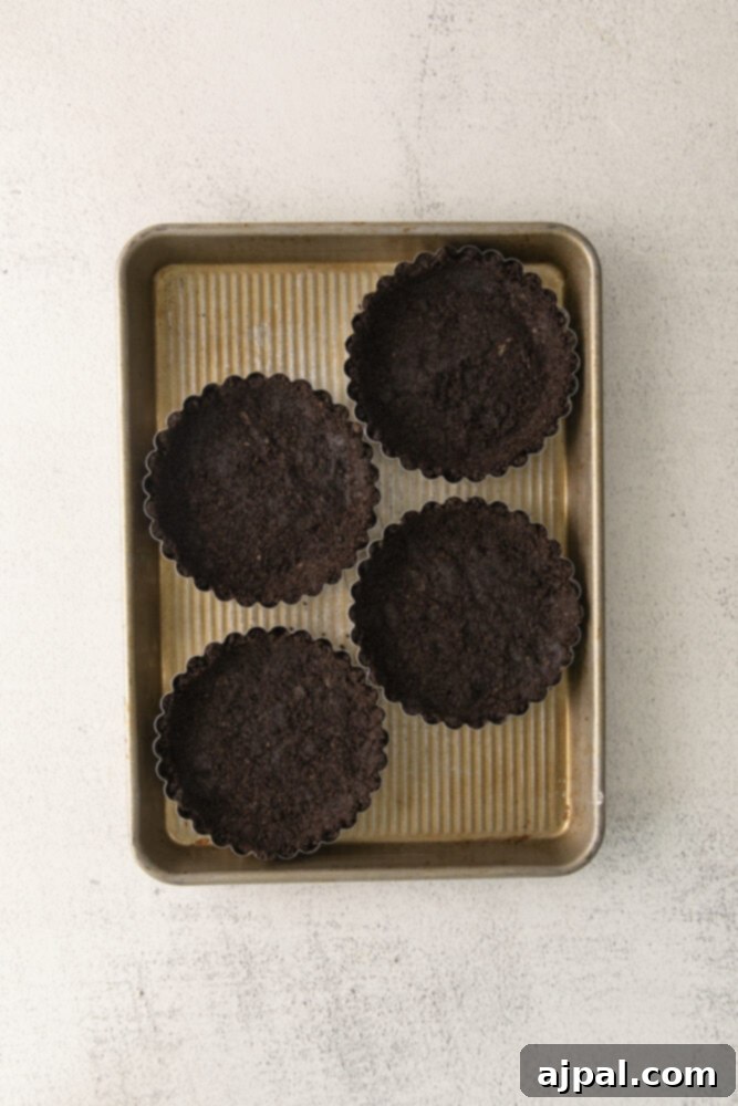 Dark Forest Cherry Delights 6 An Oreo crumb tart base, perfectly pressed and baked, resting within a fluted tart pan, ready to be filled with the rich chocolate ganache.