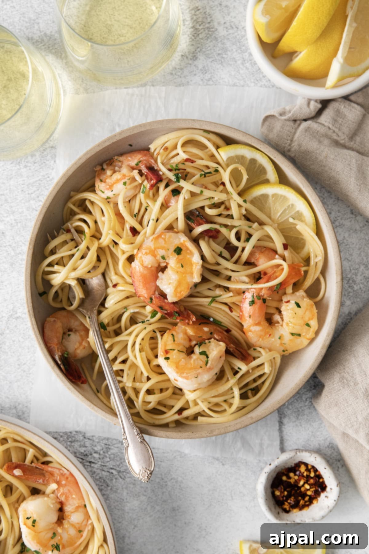 Effortless Shrimp Scampi 4 shrimp pasta with linguine, red pepper flakes, herbs, and lemon slices in a bowl