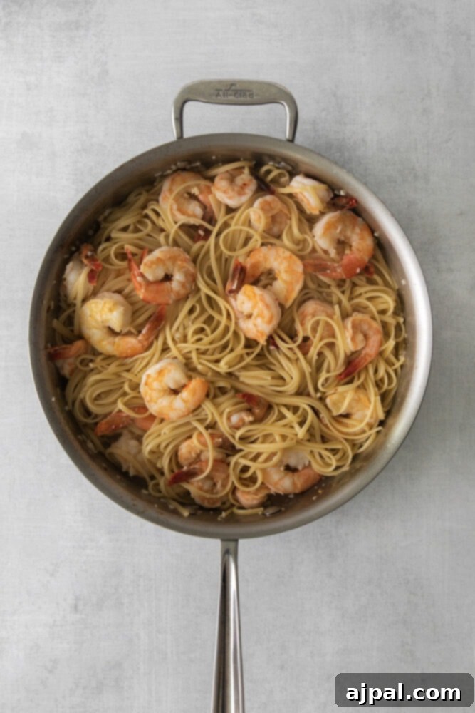 Effortless Shrimp Scampi 8 shrimp and pasta in a pan in butter and wine sauce