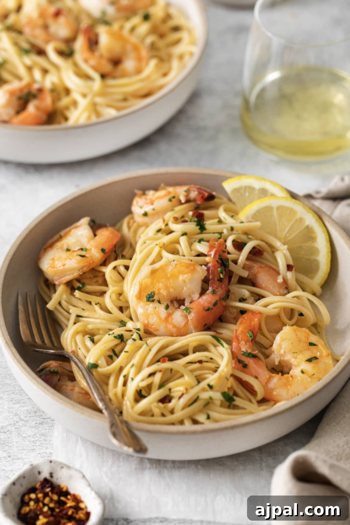 Effortless Shrimp Scampi 9 shrimp pasta with linguine, red pepper flakes, herbs, and lemon slices in a bowl