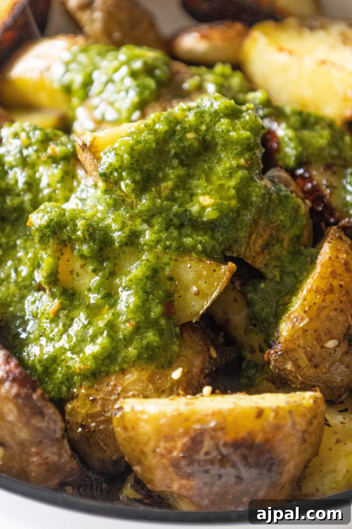 Skhug Zhoug Sauce Recipe 20 Hearty roasted potatoes, golden and crisp, served in a skillet and generously topped with vibrant cilantro zhoug sauce, presenting a delicious and satisfying meal idea.