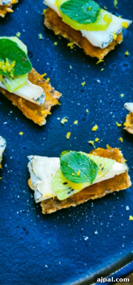 Skhug Zhoug Sauce Recipe 3 An elegant arrangement of cheese appetizers on a sleek black plate, garnished with a slice of kiwi and a fresh sprig of mint, embodying the fresh, natural produce sourced from Farma Cultura.