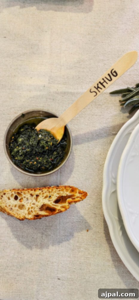Skhug Zhoug Sauce Recipe 5 A vibrant bowl of freshly prepared skhug sauce rests on a rustic wooden table, its bright green hue a visual promise of the delicious and spicy flavors inherent in Israeli cuisine.