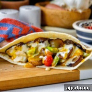 sabich sandwich with fried eggplants, fried mushrooms, Israeli salad, amba sauce, tahini sauce and hummus in a pita