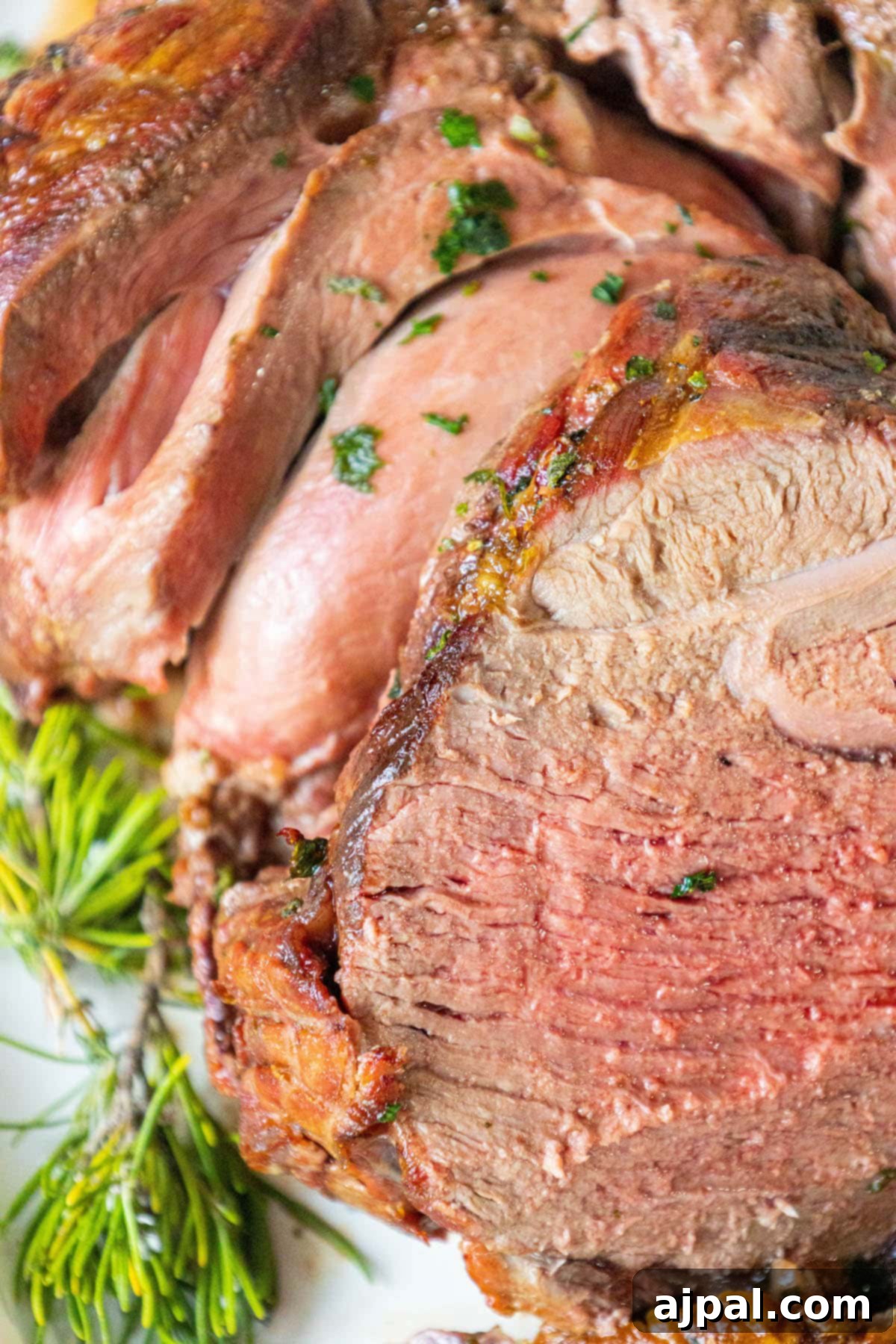 The Ultimate Easy Roasted Leg of Lamb 2 A beautifully roasted leg of lamb, perfectly sliced on a cutting board and garnished with fresh chopped herbs, ready to be served for a special meal.