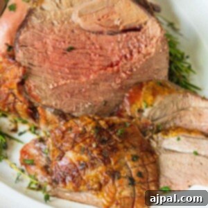 A roasted leg of lamb, sliced and garnished with fresh herbs, ready to be served. A perfect representation of the dish.