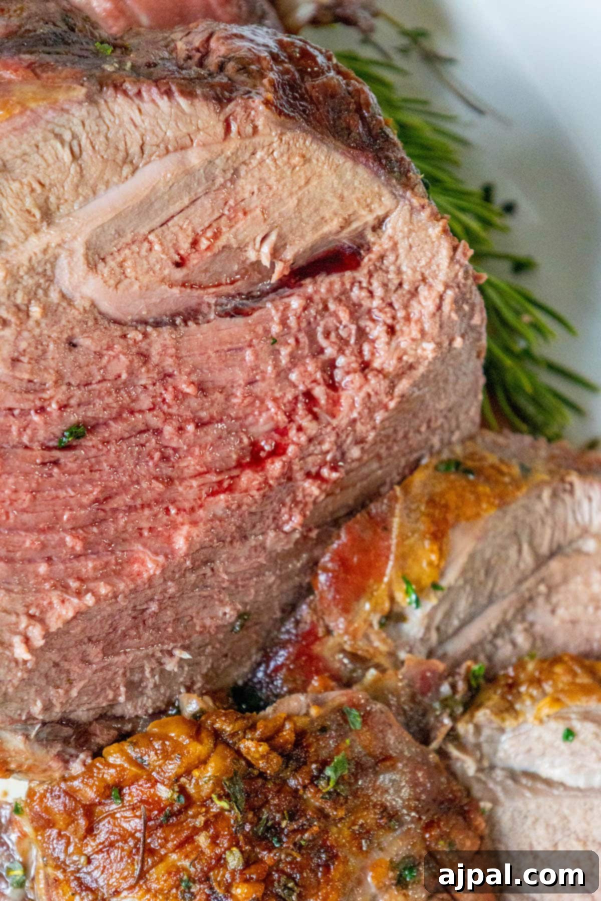 The Ultimate Easy Roasted Leg of Lamb 8 A perfectly roasted leg of lamb, adorned with sprigs of fresh rosemary and thyme, resting on a clean white plate, ready to be carved and enjoyed.